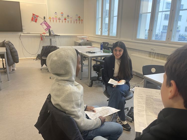 en gruppe mennesker som sitter i et rom